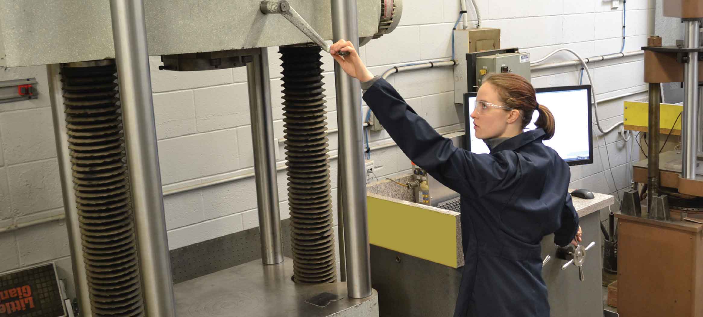 Metallurgical testing lab with female technician performing test